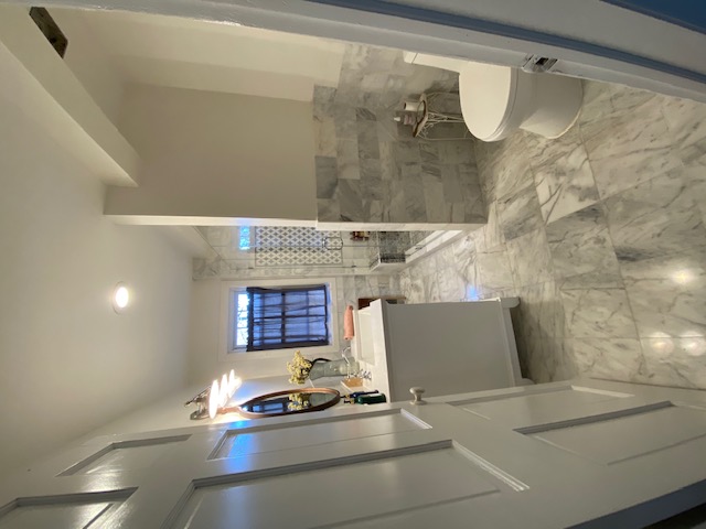 Bathroom after — full marble renovation, walk-in shower, white vanity
