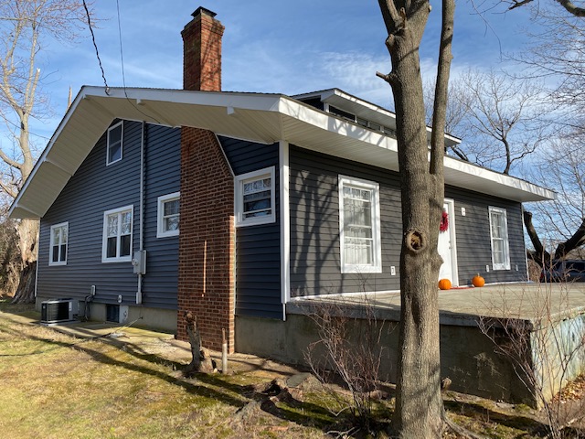 Exterior side after — complete siding and roof transformation