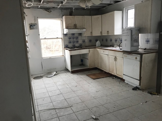 Kitchen before renovation — old cabinets and tile
