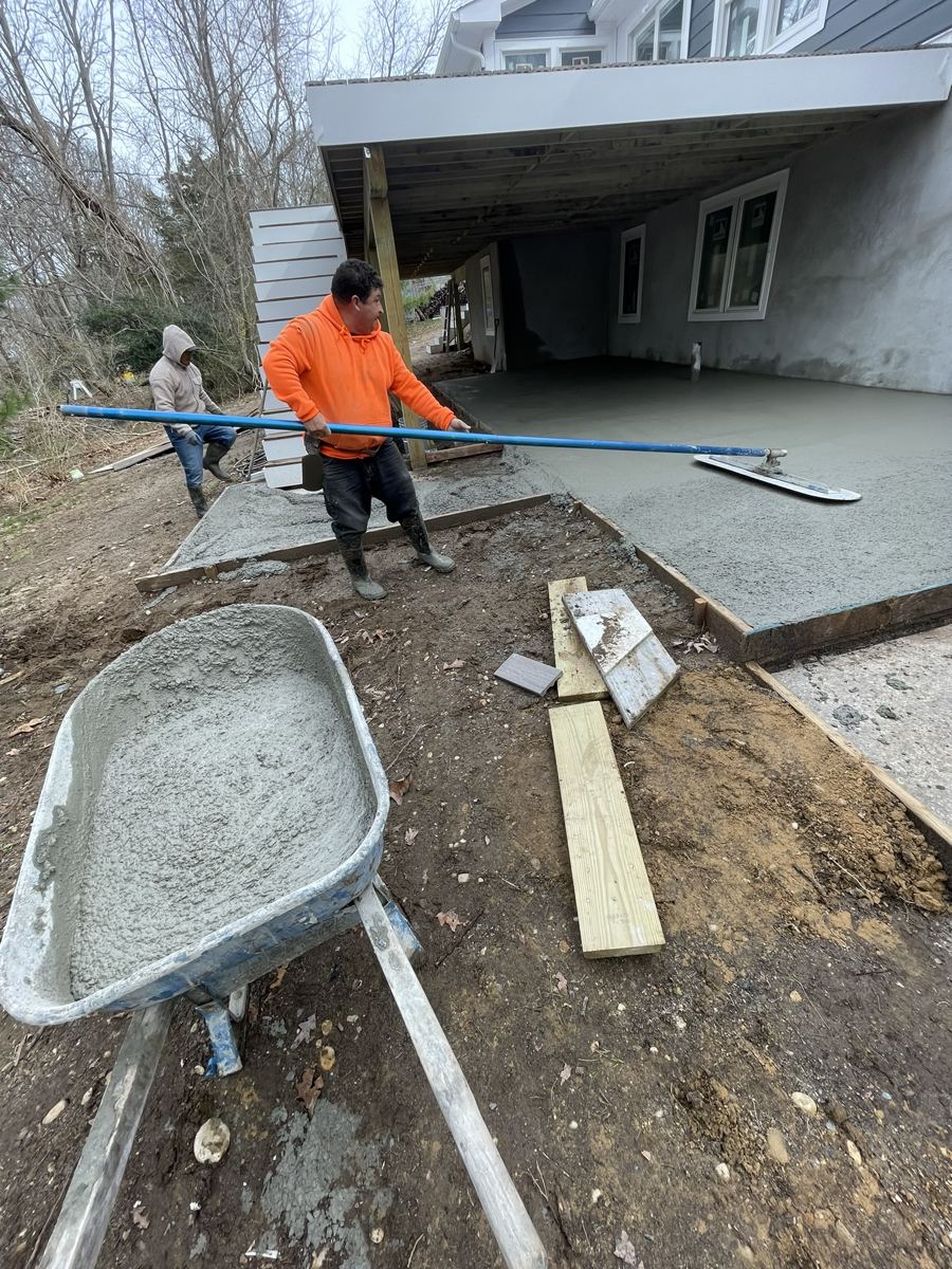 Greene Group crew finishing a fresh concrete slab under a deck